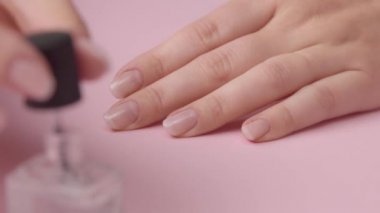 pembe üzerinde closeup kadın el kendisi için manikür yapar