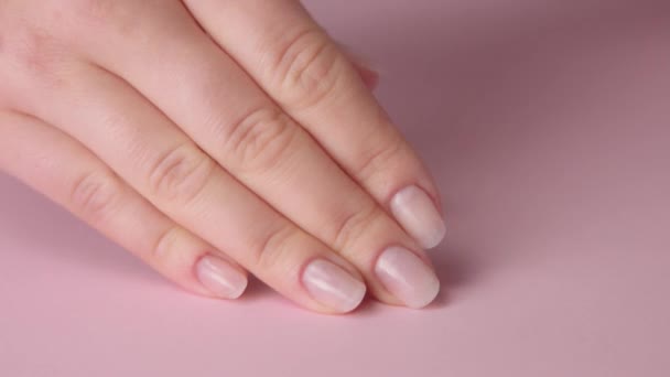 Close-up vrouw hand op roze maakt manicure voor zichzelf — Stockvideo