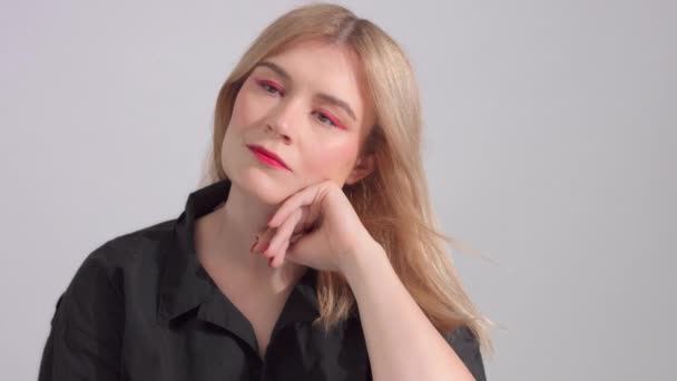 Блондинка с ярко-красным макияжем в студии — стоковое видео