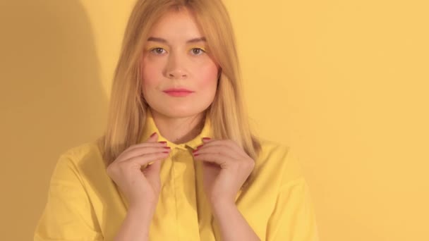 Mujer joven en ropa brillante sobre fondo amarillo brillante en el estudio — Vídeos de Stock