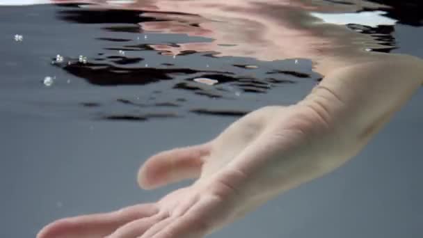 Handbeweging onder water, reflecterend wateroppervlak — Stockvideo