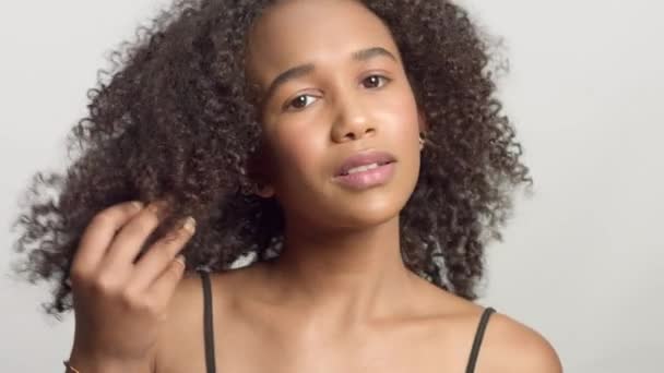 Primer plano retrato s de joven modelo de raza mixta con pelo rizado en el estudio con maquillaje natural neutro — Vídeo de stock