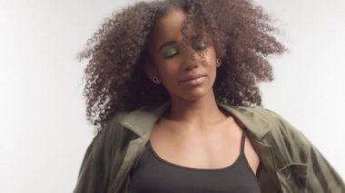 kıvırcık saçlı beyaz stüdyoda genç karışık yarış modeli, parlak yeşil göz makyajı