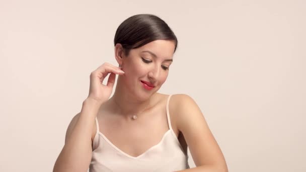 Красива брюнетка модель в студії наодинці з ідеальним блискучим портретом шкіри — стокове відео