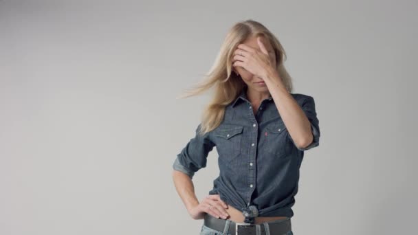 Joven belleza rubia mujer en estudio lleva denim clásico con el pelo soplado — Vídeo de stock