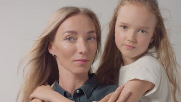 Primer plano estudio retrato de la madre con su hija la abraza y la besó — Vídeo de stock