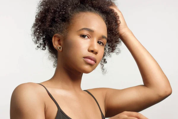 Close-up retrato de jovem modelo de raça mista com cabelo encaracolado em estúdio com maquiagem neutra natural — Fotografia de Stock