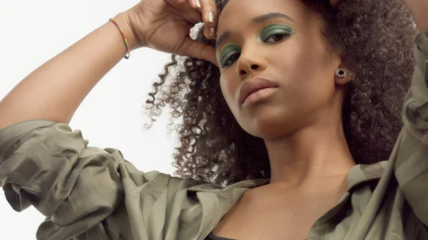 Close-up retrato s de jovem modelo de raça mista com cabelo encaracolado em estúdio com sombras metálicas verdes — Fotografia de Stock