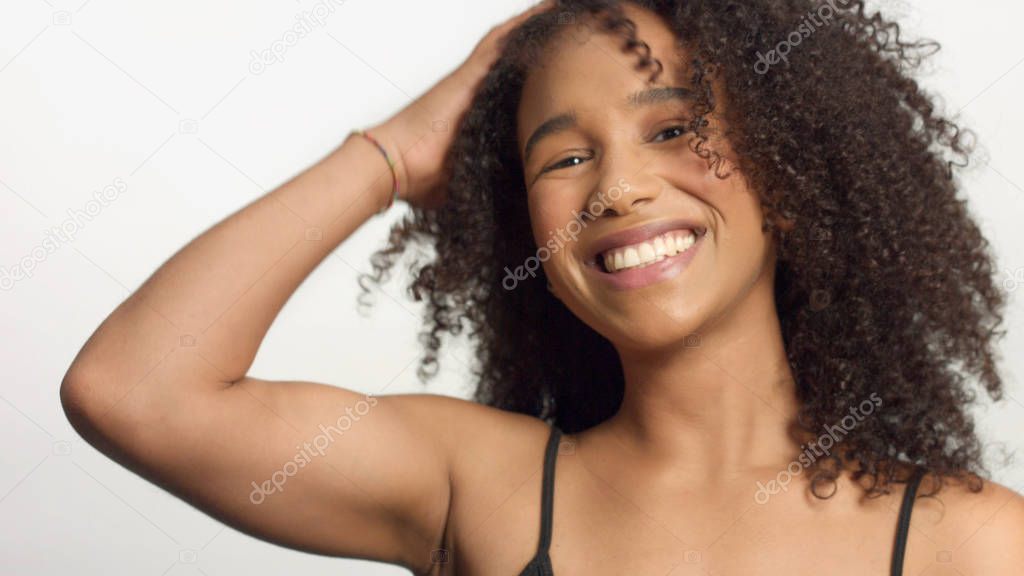 closeup portrait s of young mixed race model with curly hair in studio with natural neutral makeup