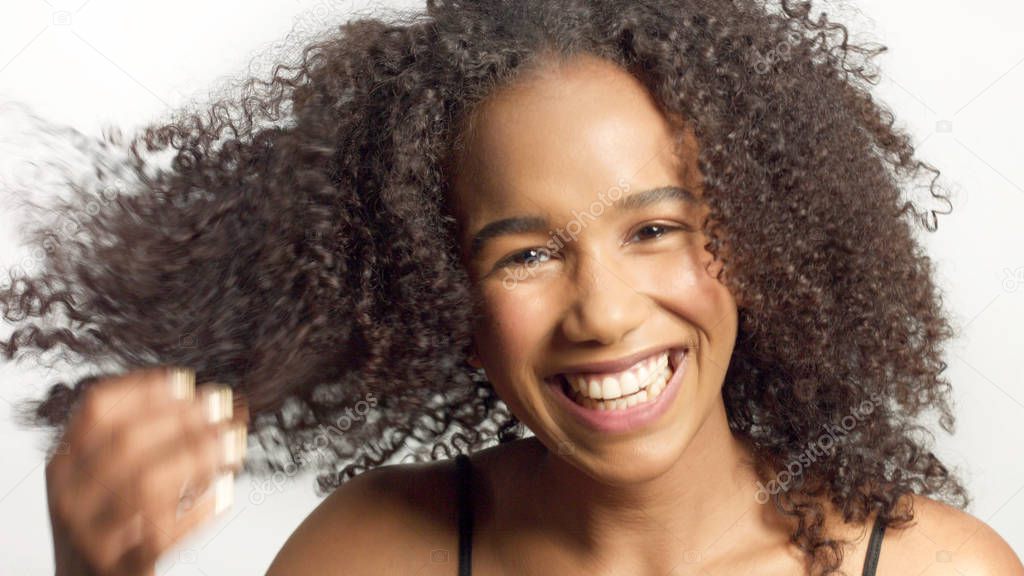 closeup portrait s of young mixed race model with curly hair in studio with natural neutral makeup