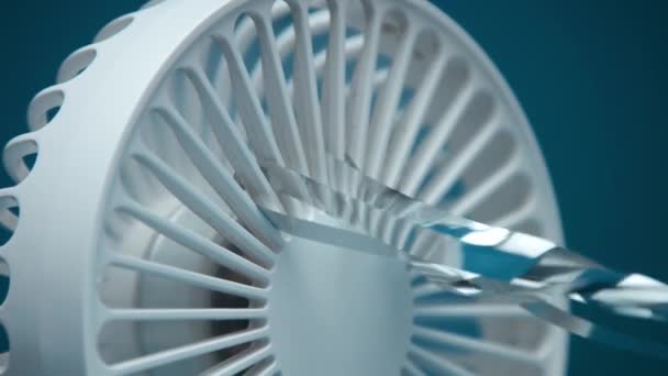 Gekantelde beelden van kleine witte ventilator blazen zilveren regenstrips — Stockvideo