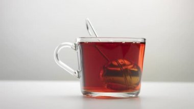 bir çay infuser kaşık şeffaf bir çay bardağı içine yavaş hareket hareket eder