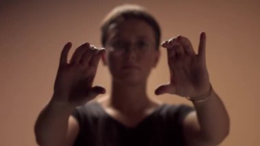 Kadın, odak noktasındaki kameraya doğru itme hareketi yapıyor.