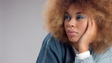 Büyük afro saçlı, melez zenci bir kadının yakın plan portresi. 