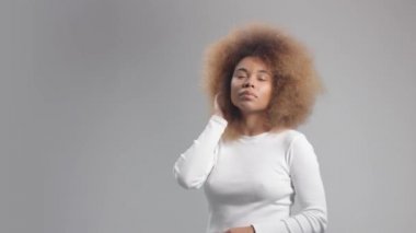 Stüdyoda uzun saçlı, melez zenci bir kadın.