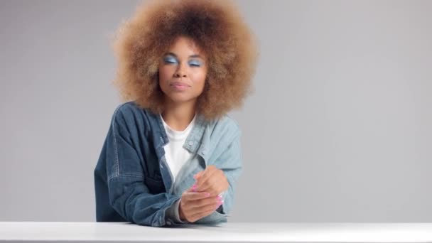 Черная женщина смешанной расы с большими афро-волосами в студии одна в джинсовой рубашке — стоковое видео