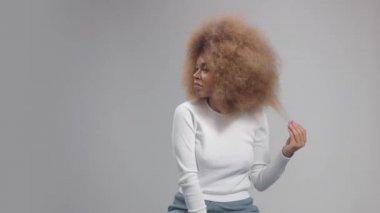 Stüdyoda uzun saçlı, melez zenci bir kadın.