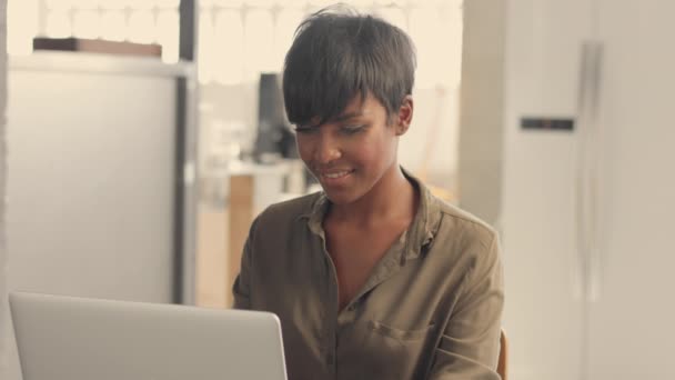 Mixed race black adult woman with short hairstyle working at home — Stock Video