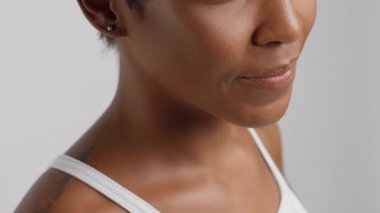 Kısa saçlı, gülümseyen, melez siyahi kadının yakın çekimi.