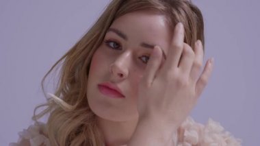Saç üfleyen genç ve güzel bir kadının yakın plan portresi. Romantik tarz modeli