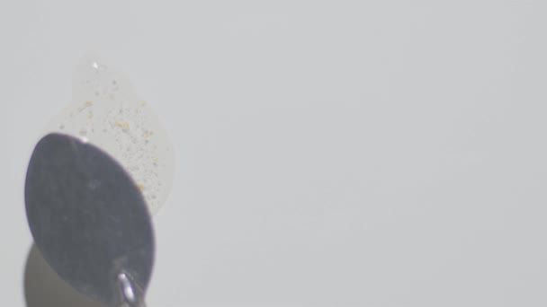 Διαφανές τζελ ορού με χρυσά σωματίδια που μουτζουρώνονται από σπάτουλα — Αρχείο Βίντεο