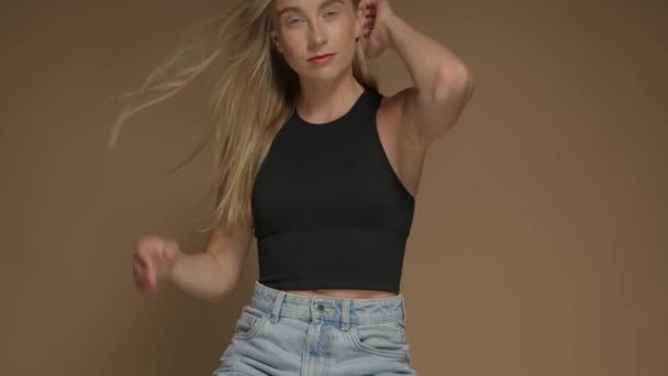 Jong surf stijl model met lang blond haar en blauwe ogen in de studio met haar blazen — Stockvideo