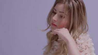 İspanyol modelin yakın plan portresi, sarı saçlar yavaş çekimde uçuşuyor.