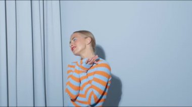 Eğlenceli mutlu genç kız dans ediyor ve stüdyoda surat asıyor.