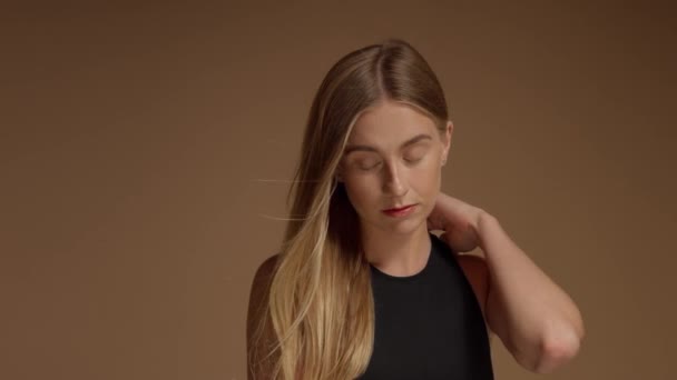 Ruhiges Blondmodel mit blauen Augen posiert im Studio vor einer anderen Kamera und streicht ihr die Haare weg — Stockvideo
