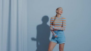 Eğlenceli mutlu genç kız dans ediyor ve surat yapıyor. 