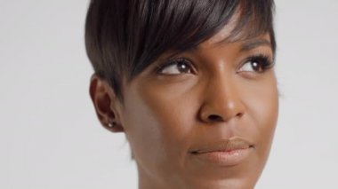 Ön manzara, kısa kesimli, kameraya bakıp gülümseyen melez bir kadının portresi.