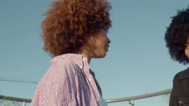 Mutlu iki melez kadın dışarıda konuşuyor ve gülüyor. 