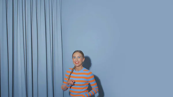 Porträt einer jungen Frau im blauen Raum, die lächelt — Stockfoto