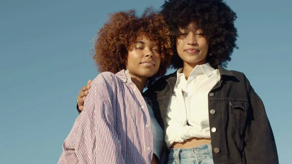 Due donne nere di razza mista si abbracciano Ritratto esterno di due donne di razza mista con enormi capelli afro — Foto Stock