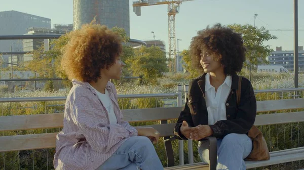 Un par de mujeres negras de raza mixta en el parque sentadas y hablando —  Fotos de Stock