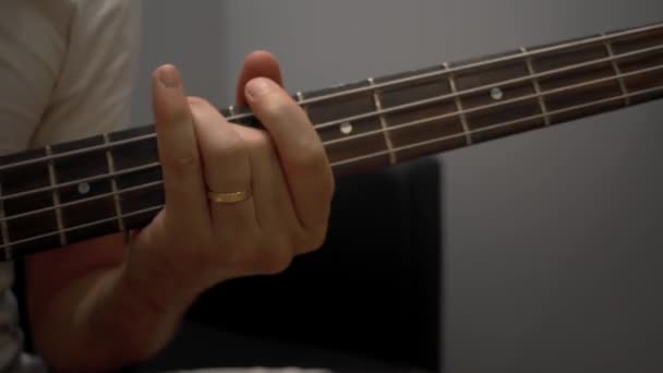 Primer plano de la mano del hombre tocando en el bajo y pines de afinación — Vídeos de Stock