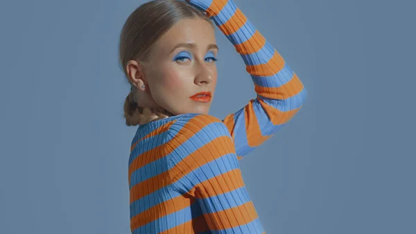 Modelo bastante joven con coloridos relojes de maquillaje a la cámara — Foto de Stock