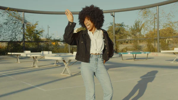 Mujer negra con enorme pelo afro y ropa estilo disco Bailando al aire libre en zona de parque de tenis —  Fotos de Stock