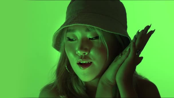 Koreaans model in studio met gekleurd groen licht en water reflectie maken gezichten — Stockvideo