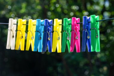 İpe asılı bir grup çok renkli mandal.