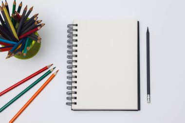 Boş spiral defter ile beyaz sayfa ve mavi bir tabloda çok renkli ileti örneği. Çalışma alanı renkli arka plan üstünde not etmek ile. Eskiz defteri giriş metni, en iyi görünüm için. Geri okul kavramı.