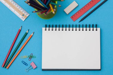 Boş spiral defter ile beyaz sayfa ve mavi bir tabloda çok renkli ileti örneği. Çalışma alanı renkli arka plan üstünde not etmek ile. Eskiz defteri giriş metni, en iyi görünüm için. Geri okul kavramı.