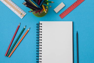 Boş spiral defter ile beyaz sayfa ve mavi bir tabloda çok renkli ileti örneği. Çalışma alanı renkli arka plan üstünde not etmek ile. Eskiz defteri giriş metni, en iyi görünüm için. Geri okul kavramı.