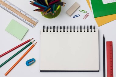 Boş spiral defter ile beyaz sayfa ve mavi bir tabloda çok renkli ileti örneği. Çalışma alanı renkli arka plan üstünde not etmek ile. Eskiz defteri giriş metni, en iyi görünüm için. Geri okul kavramı.