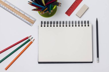 Boş spiral defter ile beyaz sayfa ve mavi bir tabloda çok renkli ileti örneği. Çalışma alanı renkli arka plan üstünde not etmek ile. Eskiz defteri giriş metni, en iyi görünüm için. Geri okul kavramı.