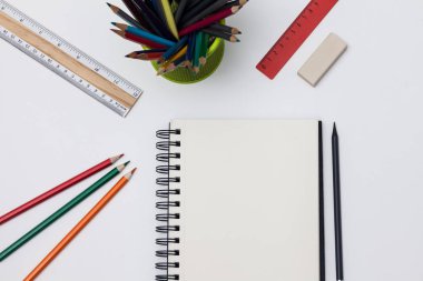 Boş spiral defter ile beyaz sayfa ve mavi bir tabloda çok renkli ileti örneği. Çalışma alanı renkli arka plan üstünde not etmek ile. Eskiz defteri giriş metni, en iyi görünüm için. Geri okul kavramı.