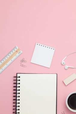 Vertical modern office desk workplace with blank notepad, pen and supplies. Copy space on color background. Top view. Flat lay style. Mockup