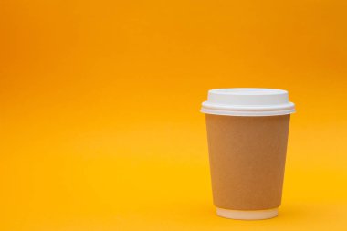 Turuncu arka plan üzerinde beyaz kapaklı kağıt kahve kabı. Paket içecek kap konteyner. Tasarımınız için içecek fincan şablonu. Giriş metni, resim ve logo için boş alan. Renkli arka plan.