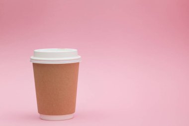 Pembe arka plan üzerinde beyaz kapaklı kağıt kahve kabı. Paket içecek kap konteyner. Tasarımınız için içecek fincan şablonu. Giriş metni, resim ve logo için boş alan. Renkli arka plan.
