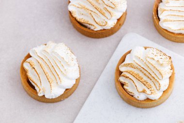 Krem şantili tart beyaz mermer mutfak masasına yakın.